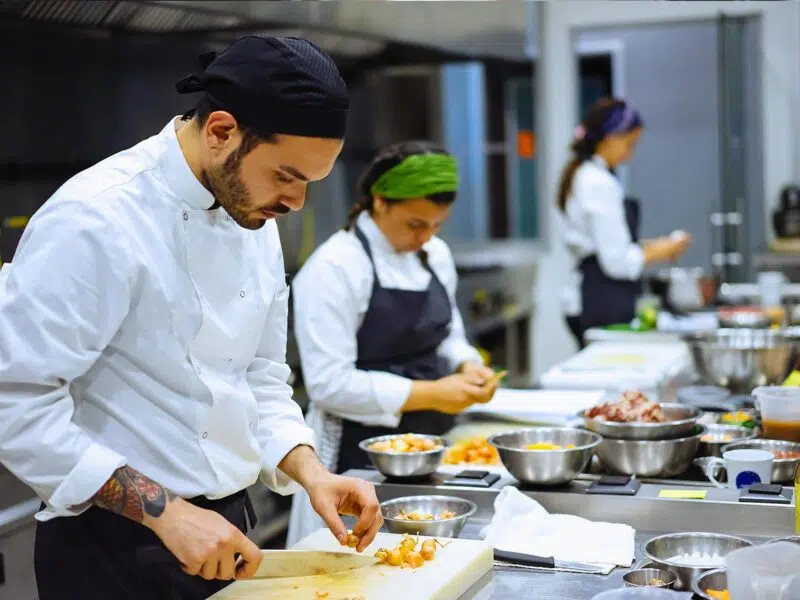 Chefs preparing food on chopping boards in a restaurant