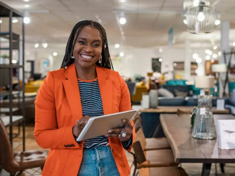 Woman smiling in bar holding a tablet