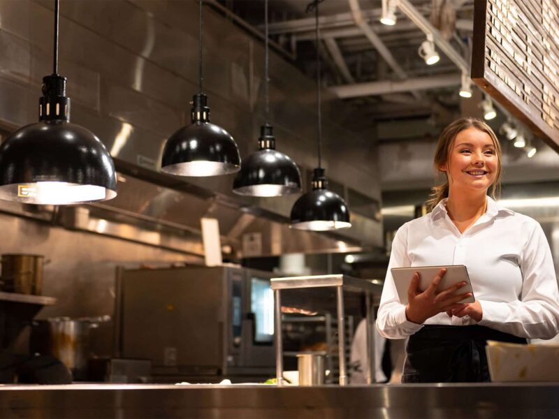 Woman in restaurant kitchen with tablet