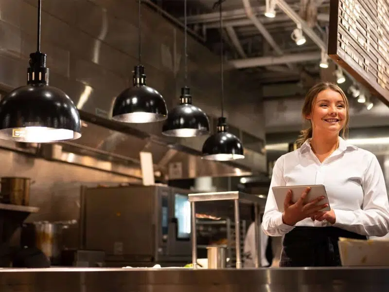 Woman in restaurant kitchen with tablet