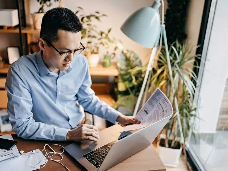 Man reading data reports using his laptop