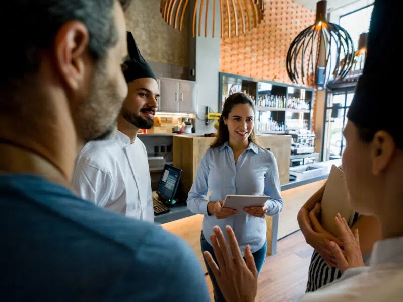 Staff planning schedules in a meeting standing in restaurant.