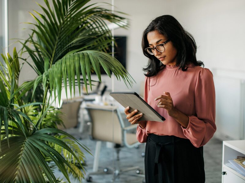 Lady in office building managing payroll with Fuego on a tablet.