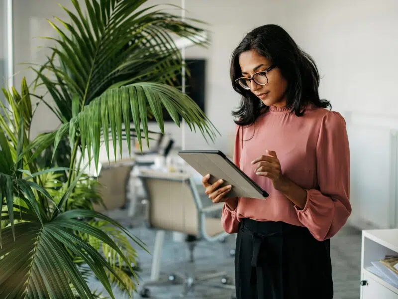 Lady in office building managing payroll with Fuego on a tablet.