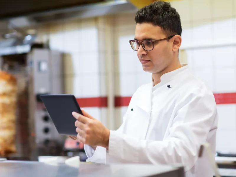 chef in the kitchen looking at a tablet