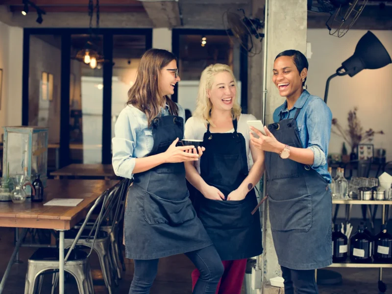 Restaurant Staff Laughing as they digitally manage tips.