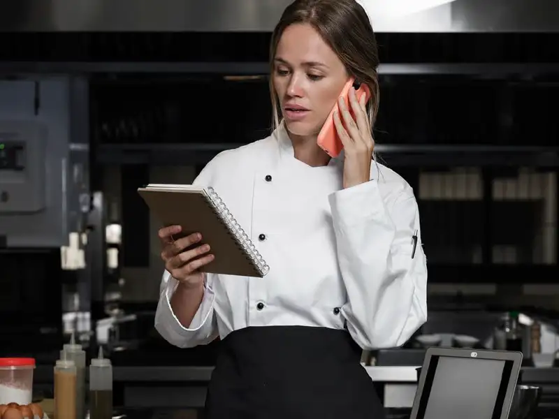 chef talking on phone looking at notes