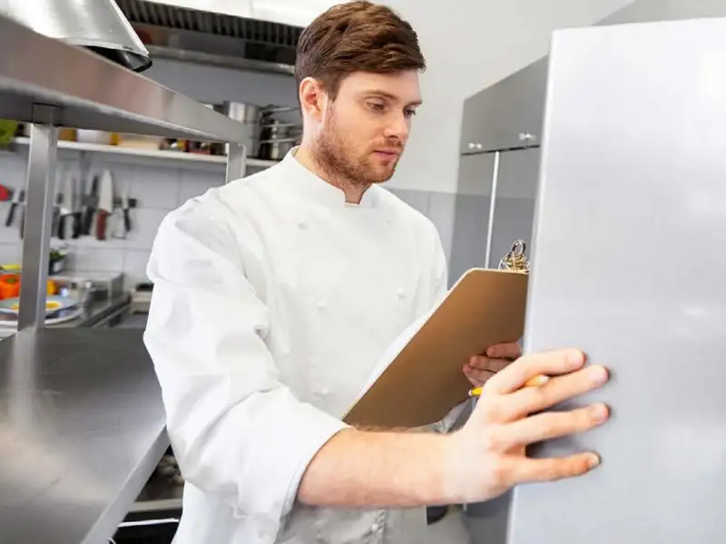 chef inspecting a regridgerator