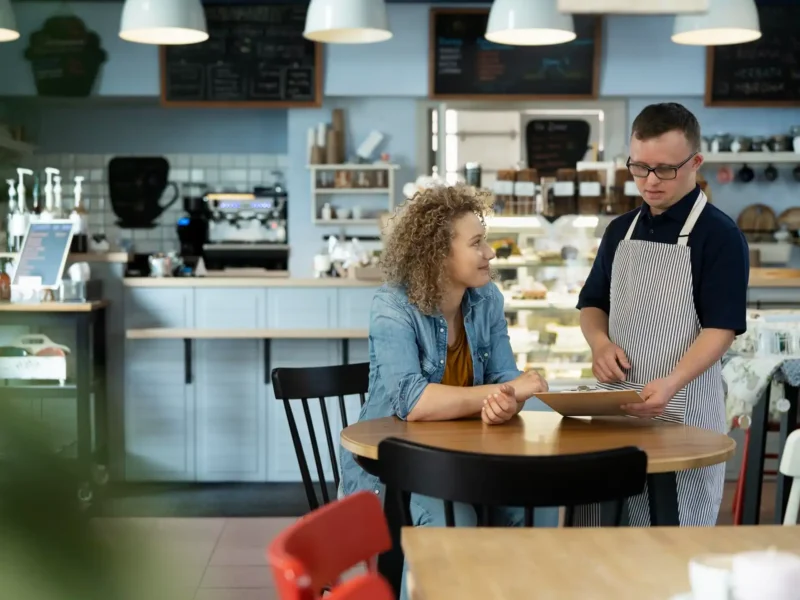 Restaurant server visiting a guest at a table