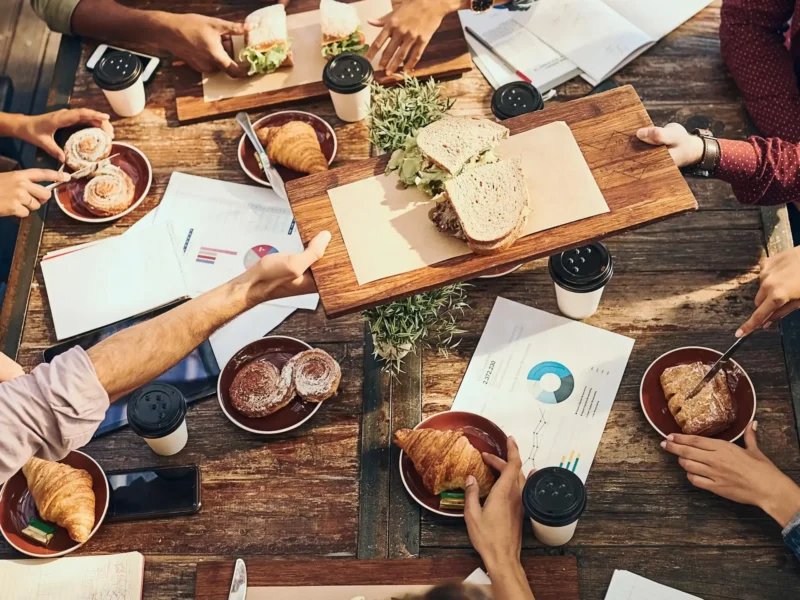 People at a table passing around food over financial reports