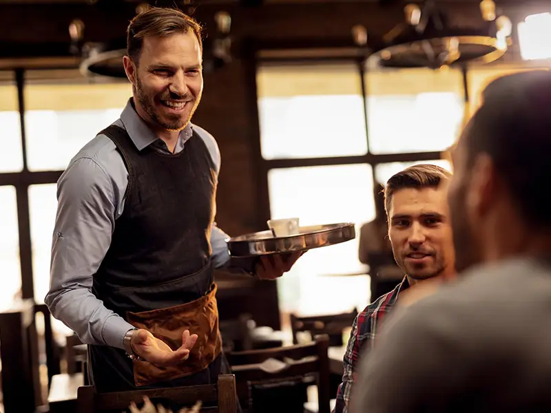 Restaurant server chatting with guests