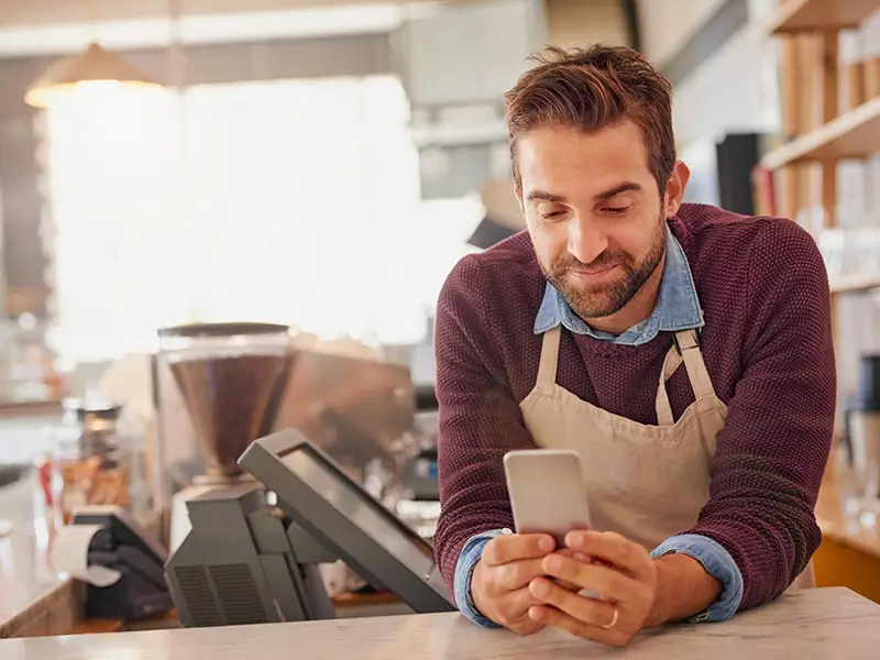 A barista looking at his phone